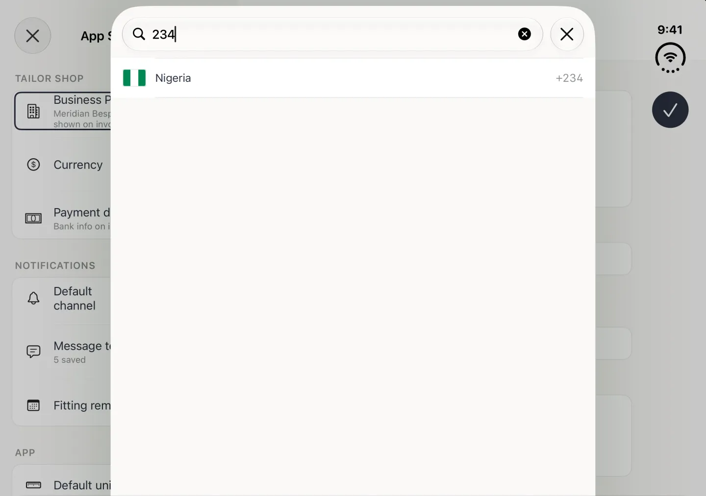 Country picker as a card over the dimmed App Settings split view in landscape, with 234 typed into the search field at the top beside a close button and a single result, Nigeria with its flag and the code +234; no on-screen keyboard (a hardware keyboard is attached).