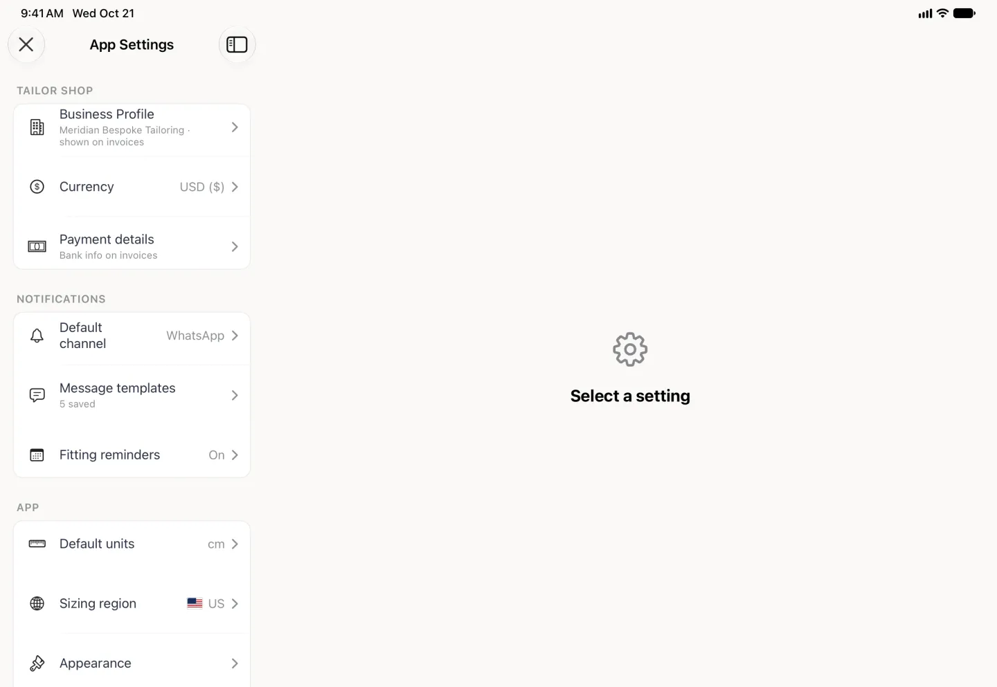 App Settings filling the screen as a split view, with a close button at the top left and a sidebar toggle beside the title: the settings list on the left with plain monochrome row icons, Business Profile (Meridian Bespoke Tailoring, shown on invoices), Currency USD ($) and Payment details (Bank info on invoices) under TAILOR SHOP, Default channel WhatsApp, Message templates 5 saved and Fitting reminders On under NOTIFICATIONS, and the APP section beginning with Default units cm, Sizing region US and Appearance; the wide pane on the right shows a gear and Select a setting.