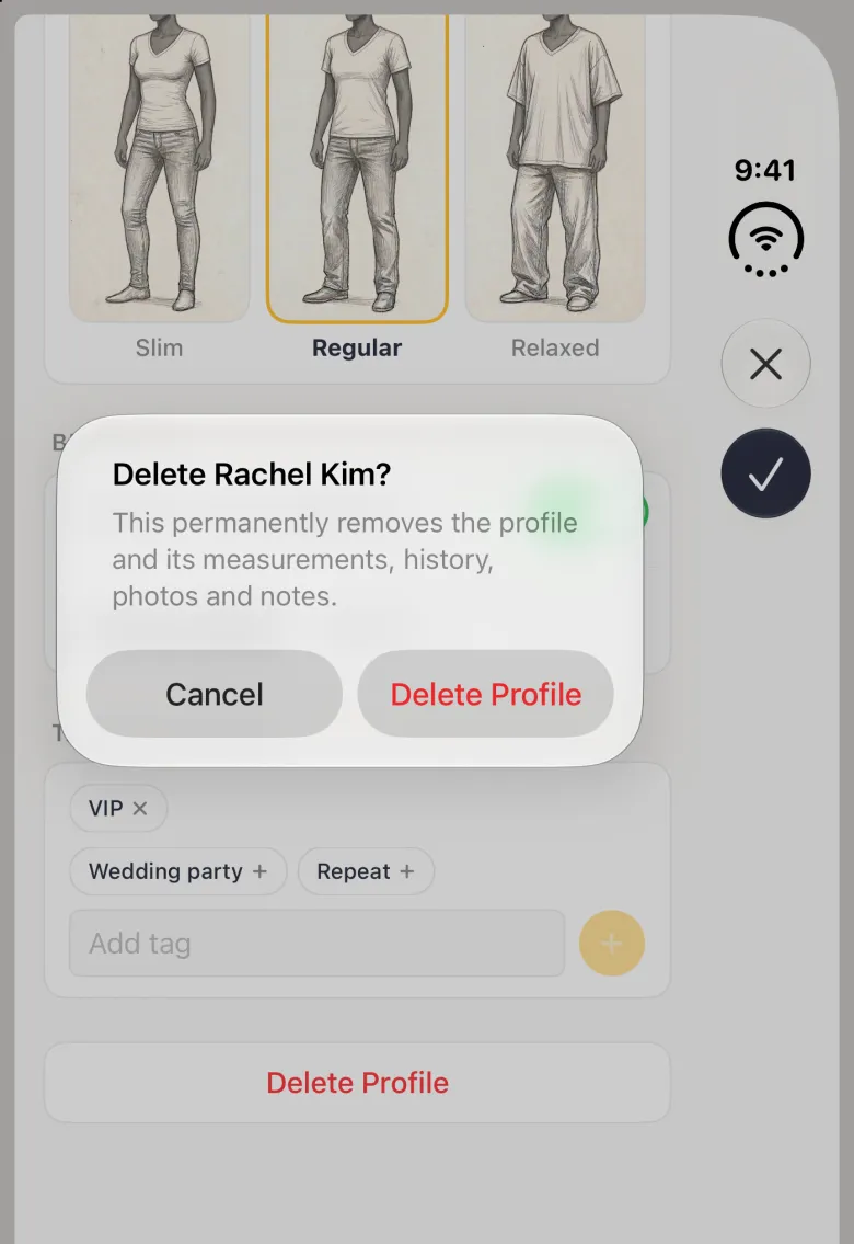 Alert titled Delete Rachel Kim? explaining that it permanently removes the profile and its measurements, history, photos and notes, with Cancel and a red Delete Profile button, over the dimmed Profile Settings sheet scrolled to its Fit Preference, Birthday, Tags and Delete Profile rows, on the closed iPhone Duo with the cross and checkmark buttons dimmed in the vertical bar strip on the right edge.