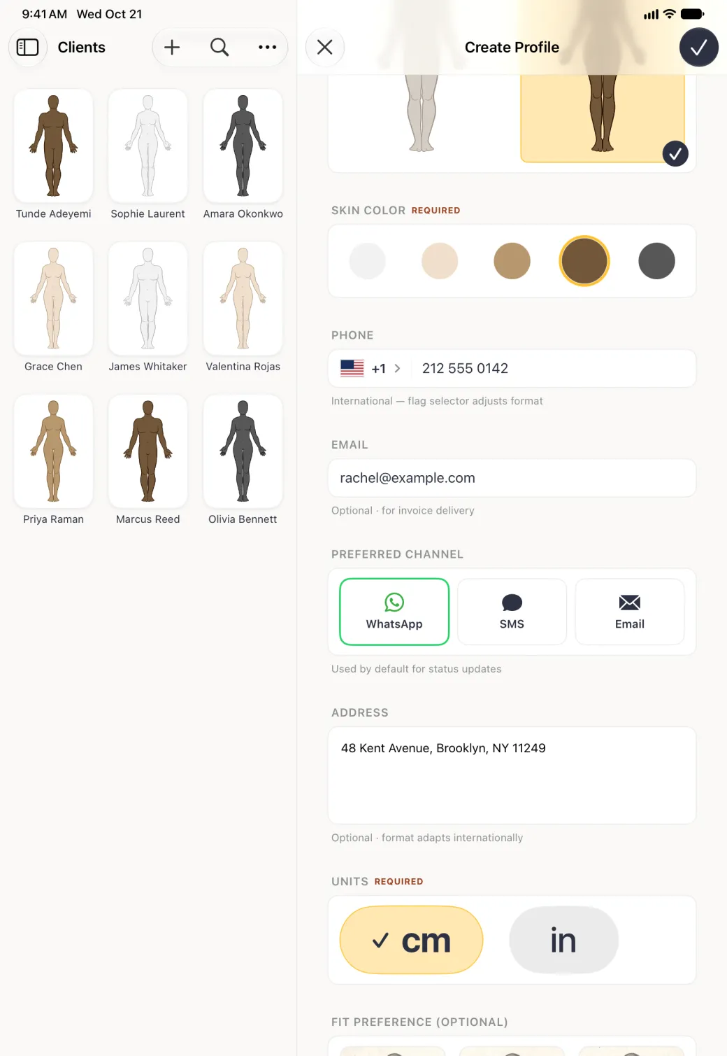 Create Profile form beside the Clients grid, scrolled so the skin tones with brown ringed in gold sit at the top, then the phone field with a US flag and +1 212 555 0142, her email under EMAIL, three PREFERRED CHANNEL cards with WhatsApp outlined in green, an ADDRESS box reading 48 Kent Avenue, Brooklyn, NY 11249, and the UNITS card with cm ticked in gold.