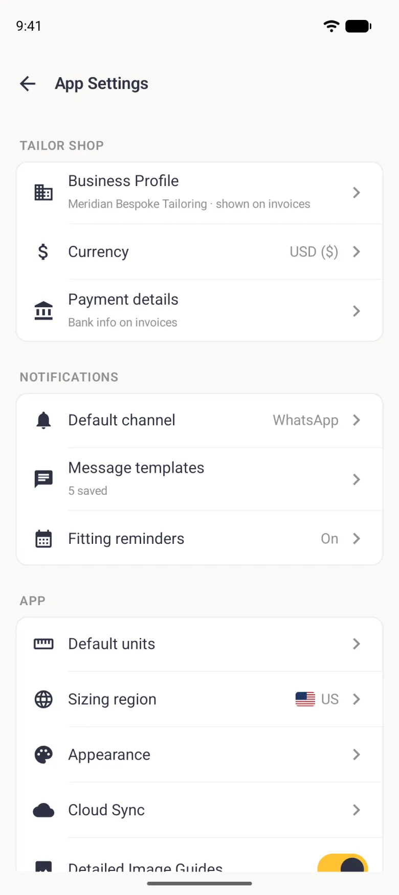 App Settings with a back arrow and three cards with plain dark icons: TAILOR SHOP with Business Profile (Meridian Bespoke Tailoring, shown on invoices), Currency USD ($) and Payment details (Bank info on invoices); NOTIFICATIONS with Default channel WhatsApp, Message templates (5 saved) and Fitting reminders On; and APP with Default units, Sizing region with a US flag and US, Appearance, Cloud Sync and Detailed Image Guides with its gold switch running under the bottom edge.