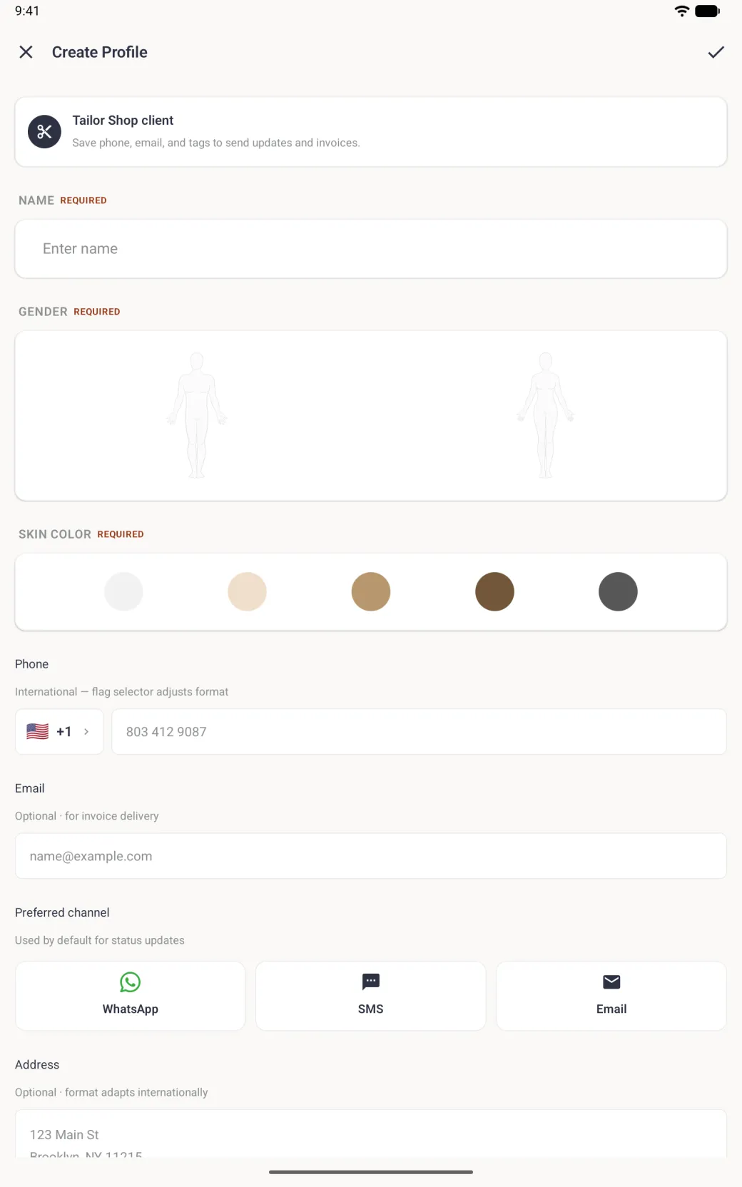 Create Profile screen on a tablet in portrait with an X and a tick in the top bar, a Tailor Shop client card explaining that phone, email and tags are used for updates and invoices, an empty Name field marked Required, a wide panel with a man and a woman outline, five skin tone circles, a Phone field with a US flag and plus one, an Email field, WhatsApp, SMS and Email channel cards, and the start of the Address box.