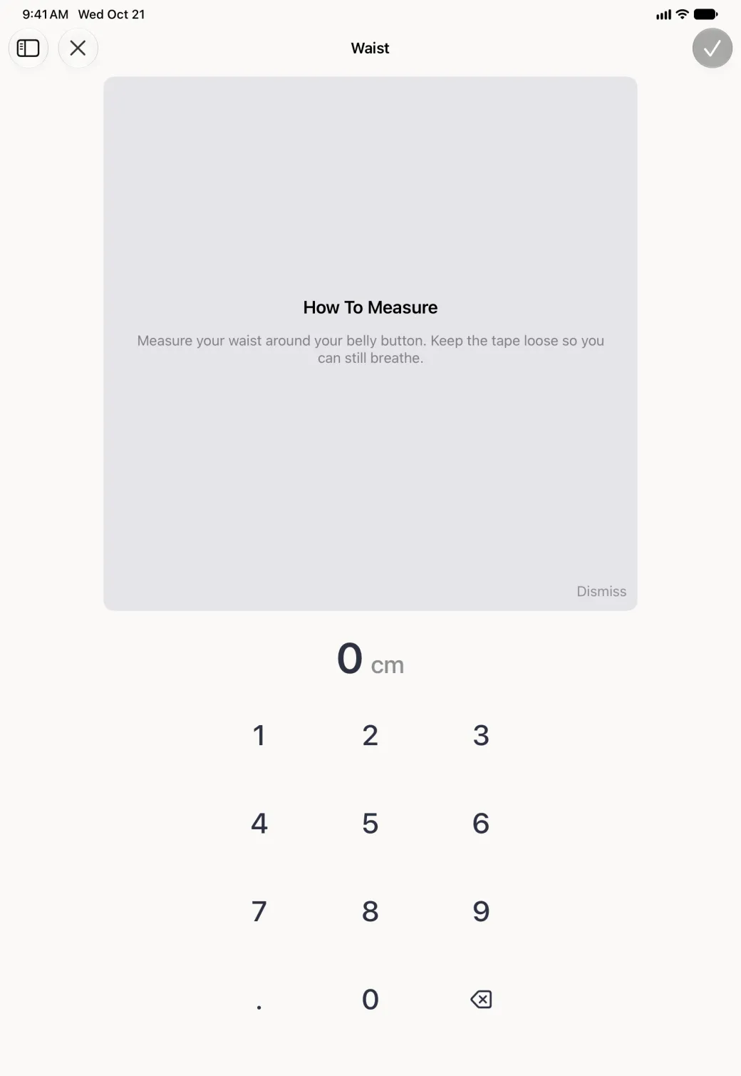 Megan Foster's Waist entry screen filling the iPad in portrait, with a sidebar button and a close button at the top left and a greyed checkmark at the top right; a large grey How To Measure panel sits in place of the illustration, reading Measure your waist around your belly button. Keep the tape loose so you can still breathe, with a Dismiss link at its bottom right, above the value 0 cm and a wide number pad.